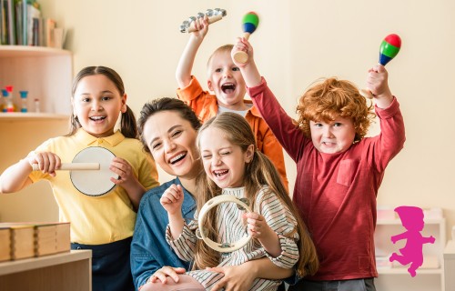 Ein lächelnder Erwachsener und vier fröhliche Kinder spielen gemeinsam in einem hellen Raum Musikinstrumente. Die Kinder halten Tamburine und Maracas in den Händen, und alle wirken glücklich. In der Ecke ist die rosa Silhouette eines Kindes zu sehen.