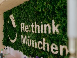Eine grüne Wand aus Moos trägt den weißen Schriftzug 